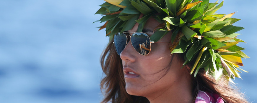 Mahina Richards is adonrned with a lei po'o that she recieved whe departing from Raiatea. The distance from Raiatea to Huahine is approximately 25 miles.