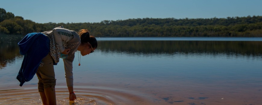Tomiko touches the sacred waters of Brown Lake.