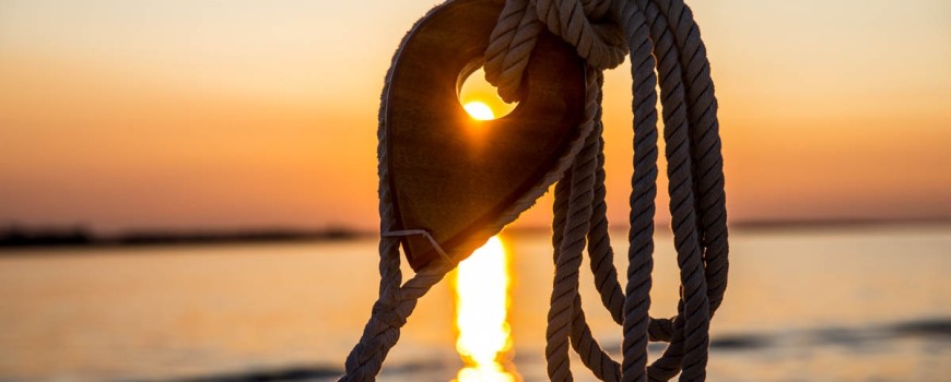 The sun sets through a port shroud deadeye.